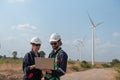 Engineers working and using a computer laptop on site in wind turbine farm Royalty Free Stock Photo