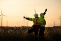 Engineers working on wind farms for renewable energy are in charge of massive wind turbine maintenance. Stand and watch the sunset