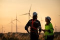 Engineers working on wind farms for renewable energy are in charge of massive wind turbine maintenance. Stand and watch the sunset