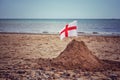 A England flag on a sand castle on a British Beach