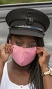 Woman driver pulling on a pink face mask