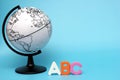 English ABC alphabet letters next to black and white globe on a blue background Royalty Free Stock Photo