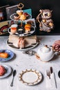 English afternoon tea set including hot tea, pastry, scones, sandwiches and mini pies on marble top table Royalty Free Stock Photo