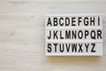 English alphabet on lightbox over white wooden surface, top view. Letters from A to Z. Back to school concept. From above, flat