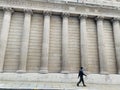 Generic architecture pillars in London and a man walking on the street Royalty Free Stock Photo