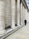 Generic architecture pillars in London and a man walking on the street Royalty Free Stock Photo