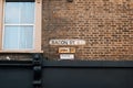 English and Bengali bilingual street name sign on a building in Bacon Street, East London, UK