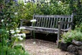 English blooming summer garden with an old bench. Relaxing and calming place. Royalty Free Stock Photo