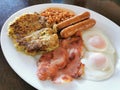 English Breakfast With Bacon Slices, Eggs, Baked Beans, Sausages And Bubble And Squeak.