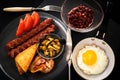 English breakfast with egg, bacon, sausages, toast, beans, mushrooms, tomatoes and juice. Fried egg in a frying pan Royalty Free Stock Photo