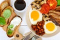 English breakfast: eggs, bacon, beans in tomato sauce, mushrooms, tomatoes, toast with cream cheese and a cup of coffee Royalty Free Stock Photo