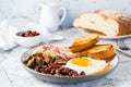 English breakfast with fried egg, bacon, beans, mushrooms and toast on a plate on the table Royalty Free Stock Photo