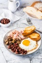 English breakfast with fried egg, bacon, beans, mushrooms and toast on a plate. Vertical view Royalty Free Stock Photo