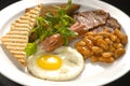 English breakfast: fried egg, bacon, beans and toast on a plate Royalty Free Stock Photo