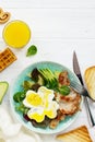 English breakfast - fried egg, fried bacon, spinach, arugula, avocado, toast and orange juice. Royalty Free Stock Photo