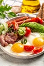 English breakfast. Fried egg, sausage, bacon, avocado, beans and toast on white background Top view, overhead, vertical image Royalty Free Stock Photo