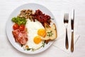 English Breakfast, fried eggs, ham, mushrooms on a white plate with a knife and fork Royalty Free Stock Photo