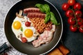 English breakfast. Fried eggs, sausages, bacon, beans, toasts, tomatoes on stone table. Top view with copy space. Royalty Free Stock Photo