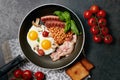 English breakfast. Fried eggs, sausages, bacon, beans, toasts, tomatoes on stone table. Top view with copy space. Royalty Free Stock Photo