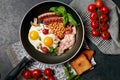 English breakfast. Fried eggs, sausages, bacon, beans, toasts, tomatoes on stone table. Top view with copy space. Royalty Free Stock Photo
