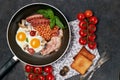 English breakfast. Fried eggs, sausages, bacon, beans, toasts, tomatoes on stone table. Top view with copy space. Royalty Free Stock Photo