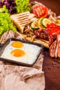 English breakfast with fried eggs, sausages, bacon, vegetables, bread Royalty Free Stock Photo