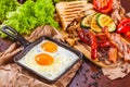 English breakfast with fried eggs, sausages, bacon, vegetables, bread and spices Royalty Free Stock Photo