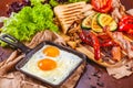 English breakfast with fried eggs, sausages, bacon, vegetables, bread and spices Royalty Free Stock Photo