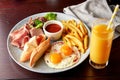 English Breakfast including ham, egg with bacon, french fries and vegetables