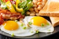 English breakfast macro: fried eggs, bacon, beans, toast and fre Royalty Free Stock Photo