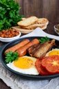 English breakfast: sausages, bacon, tomatoes, egg, beans in sauce, fried mushrooms, toast Royalty Free Stock Photo