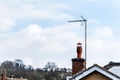English brick chimney and TV antenna on lovely light blue sky