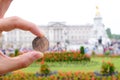 English coin picturing the Queen in front of Buckingham Palace.