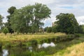 English countryside stream with cathedral in distance