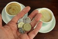English Currency in hand with two coffee in background. Royalty Free Stock Photo