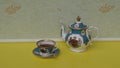 English teacup with saucer, spoon and teapot, fine bone china porcelain Royalty Free Stock Photo