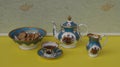 English teacup with saucer, teapot, cream jug and a cake bowl with cookies, fine bone china porcelain