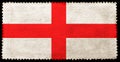 English flag on the old grunge postage stamp isolated on black background. Red cross on white backdrop Royalty Free Stock Photo
