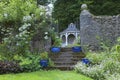 English garden with blue pots, roses, old wooden arbour Royalty Free Stock Photo