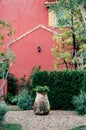 English garden with green shrubs, tree and stone vase