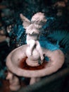 English garden : Little cupid angel sculpture on the fountain in the garden, Royalty Free Stock Photo