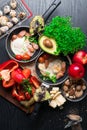 English health breakfast for two. Fried eggs with sausages in a frying pan with spices and fresh vegetables, cheese, nuts Royalty Free Stock Photo