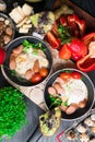 English health breakfast for two. Fried eggs with sausages in a frying pan with spices and fresh vegetables, cheese, nuts Royalty Free Stock Photo