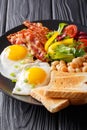 English homemade breakfast: fried eggs with bacon, beans, toast