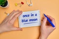 English idiom hand lettering about time - once in a blue moon on wooden blocks