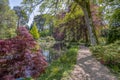 An English landscape garden in Spring with a path going around a pond Royalty Free Stock Photo
