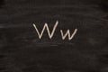 An English letter W drawn in chalk on a blackboard.