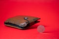 English money - fifty pence on red backdrop. Blurred wallet in the background. Saving money for future