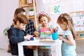 English teacher with children have fun and playing games, learning alphabet and numbers by arts in kid childcare center Royalty Free Stock Photo