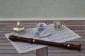 English teacup and saucer, cream jug, sugar bowl and sugar spoon, with floral decor and a block flute on a sheet of music